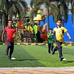 Students running on the turf playground in front of palm trees and play equipment