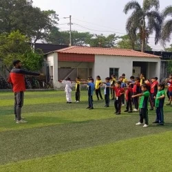Sports coach leading students in outdoor drill formation on the school ground